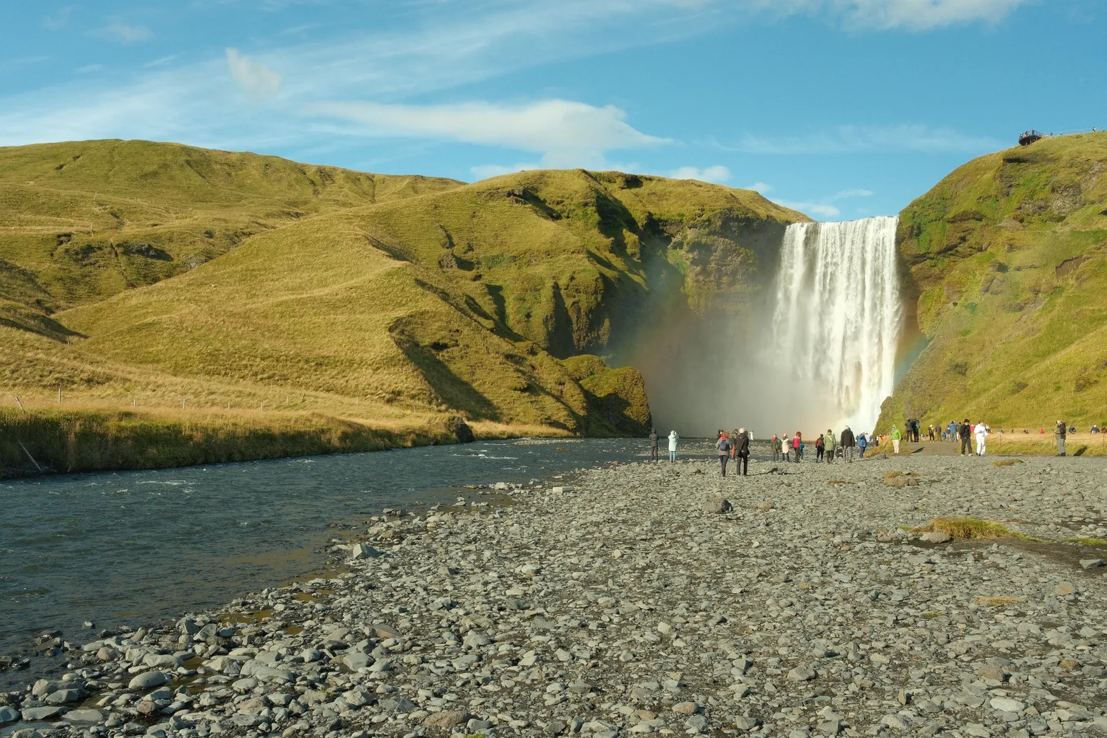 A waterfall cascades through a rugged Icelandic landscape.