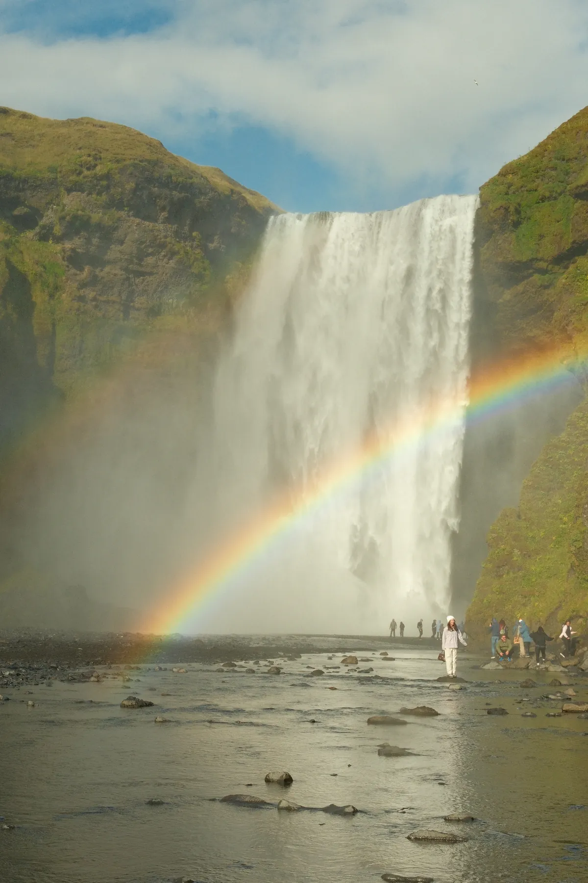 A view of Skógafoss waterfall in Iceland, displaying a rainbow.